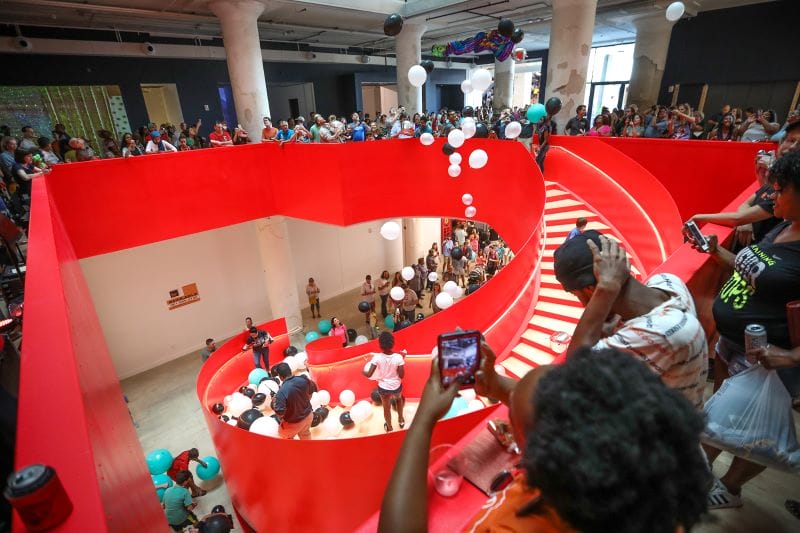 People gather on a red staircase to celebrate the opening of the Crosstown Concourse building in Memphis