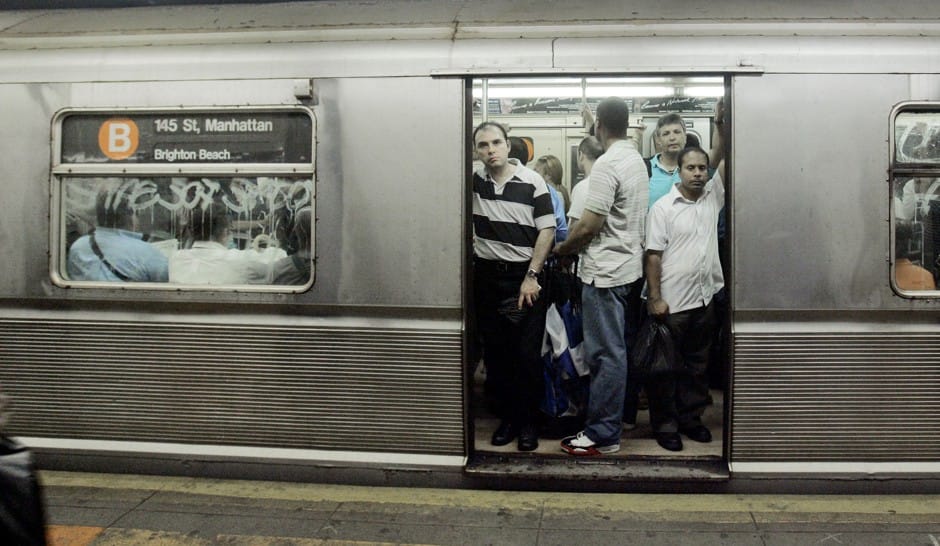 A  crowded subway car with open doors.