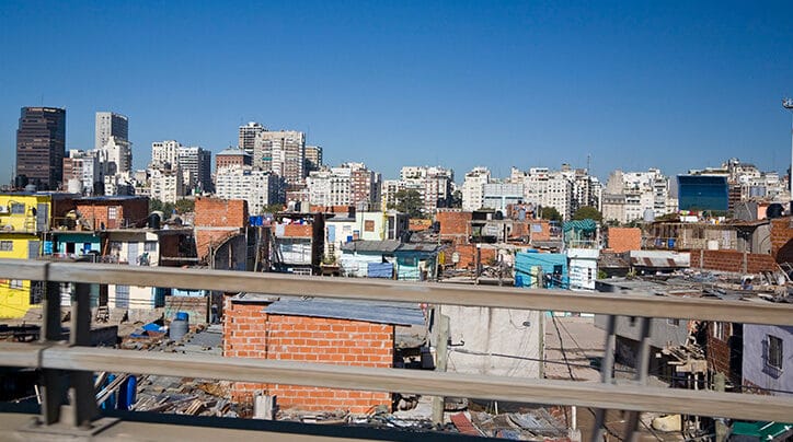 Urban skyline with tall buildings in background with informal dwellings in foreground in Buenos Aires Argentina