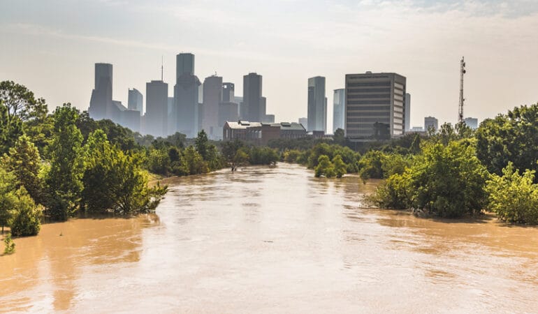Agua de inundación marrón con la ciudad de Houston en el fondo