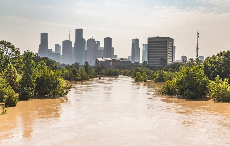Agua de inundación marrón con la ciudad de Houston en el fondo