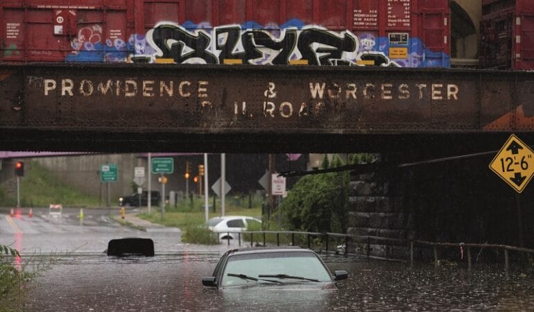 A car sits submerged under water as a results of heavy flooding. The car sits under an aging Providence & Worcester Railroad bridge in Worcester.