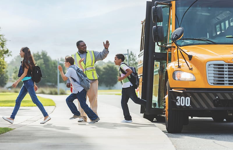 Image: Children departing a yellow school bus.