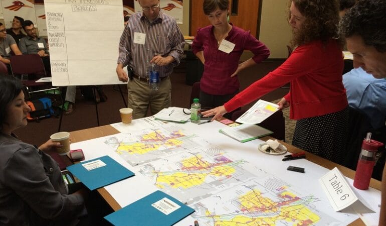 A group of planners stands over a map.