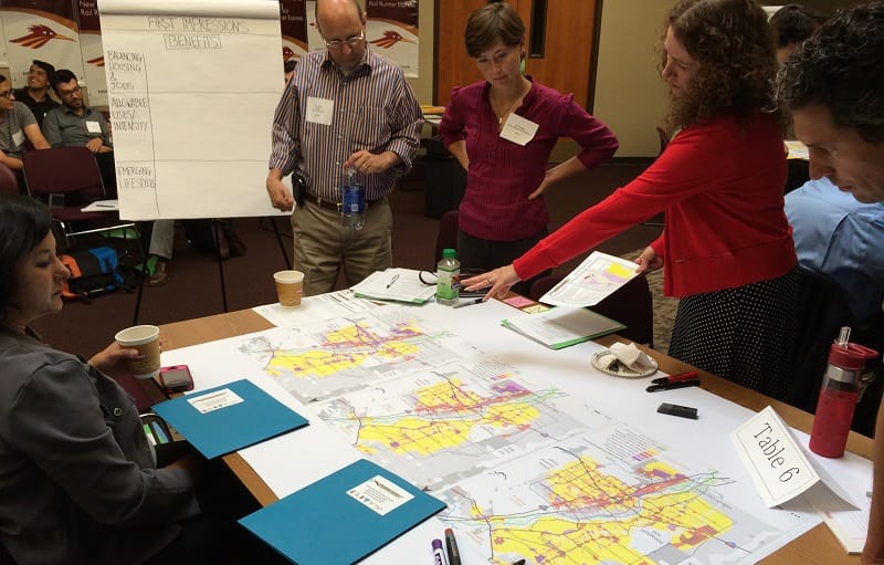 A group of planners stands over a map.
