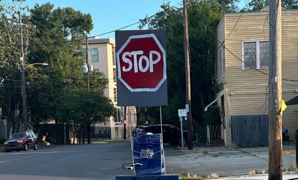 A hand-painted stop sign on a street corner in New Orleans.