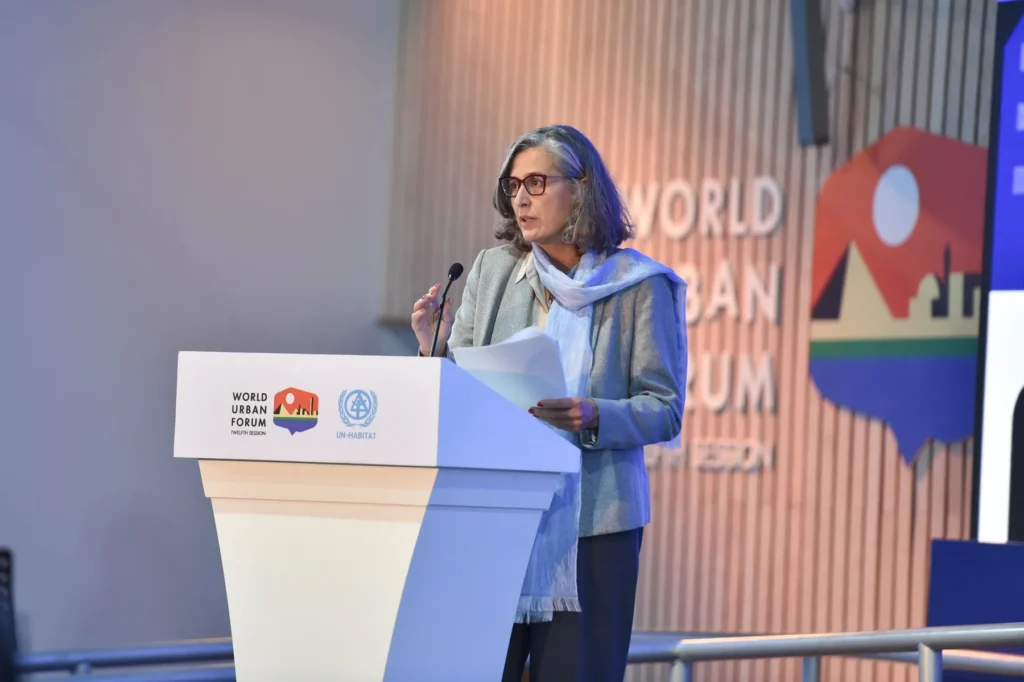 Anaclaudia Rossbach, executive director of UN-Habitat, speaks at a podium at the World Urban Forum in 2024.