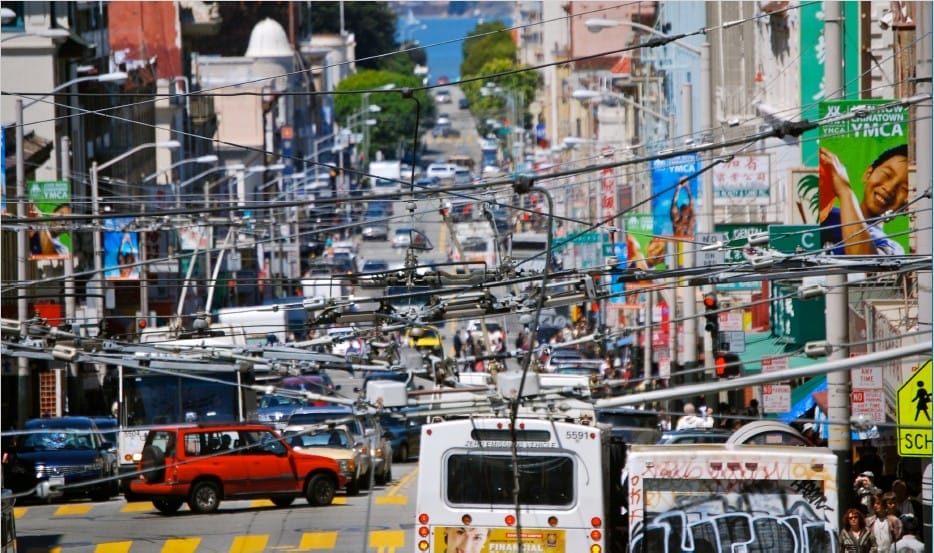 Busy San Francisco, California street with cars, buses and pedestrians in background.