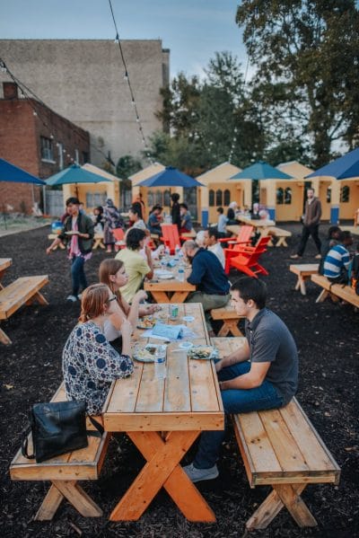 This image shows the backyard of the Exchange House, where residents are participating in an event called Multinlingual Meals.  