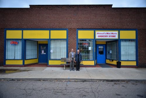 The owners of Dhimal's Mini Marts stand outside the grocery store, which is located in North Hill. 